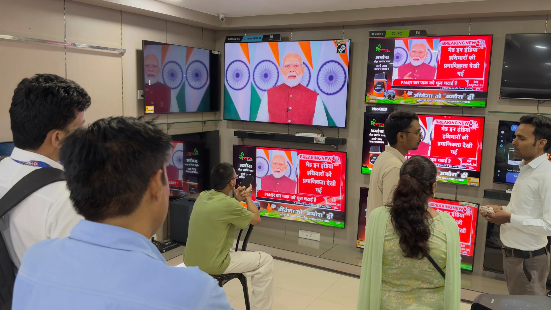 Indians watch the live telecast of Indian Prime Minister Narendra Modi's speech on television screens, in Prayagraj, in the northern Indian state of Uttar Pradesh, India, Monday, May 12, 2025. (AP Photo/Rajesh Kumar Singh)