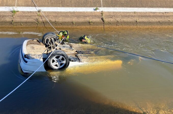 Bomberos rescatando el coche hundido en un canal de Cartaya
