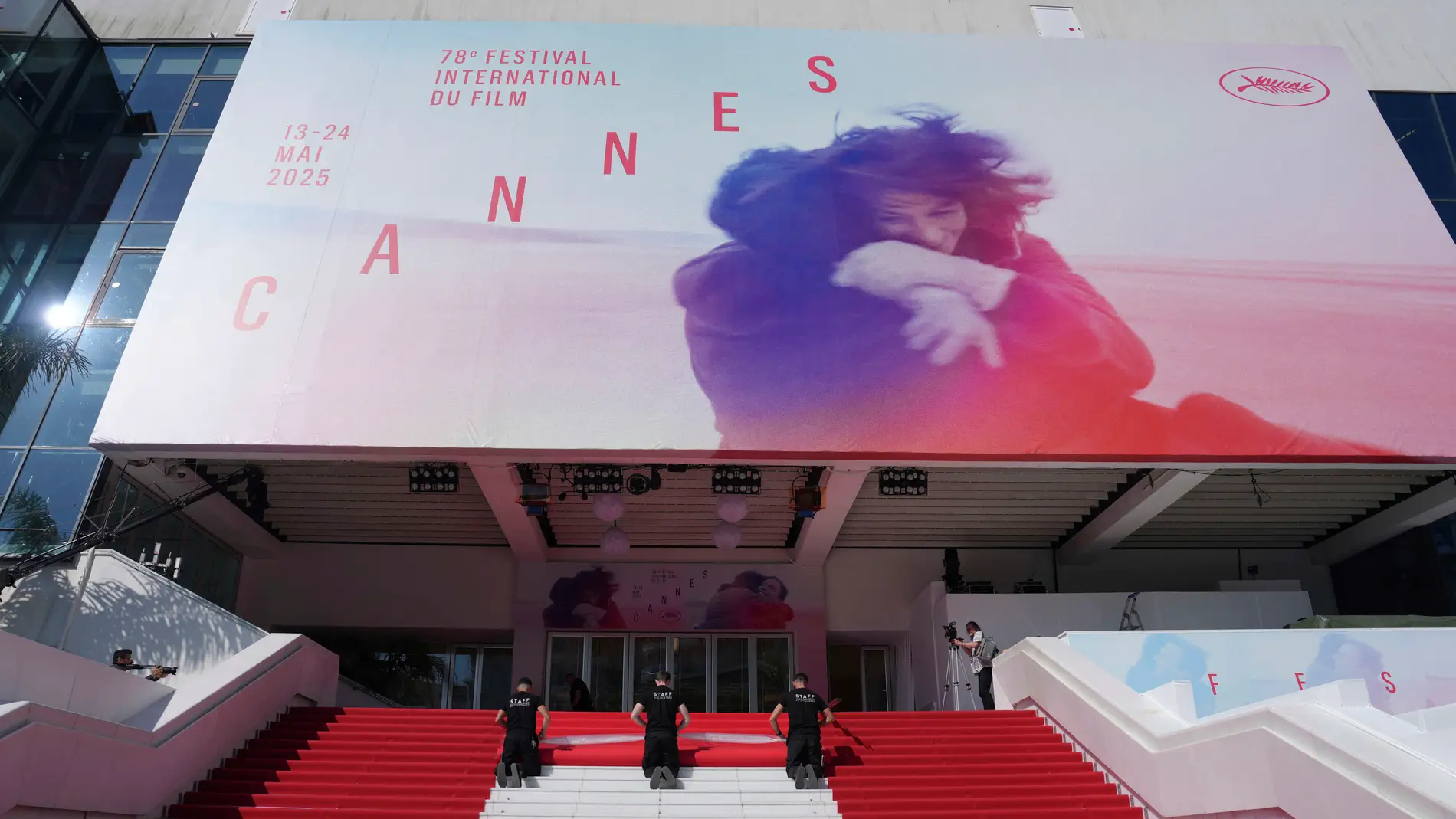 Crew members install the red carpet at the Palais des Festivals ahead of the opening ceremony of the 78th international film festival, Cannes, southern France, Tuesday, May 13, 2025. (Photo by Lewis Joly/Invision/AP)
