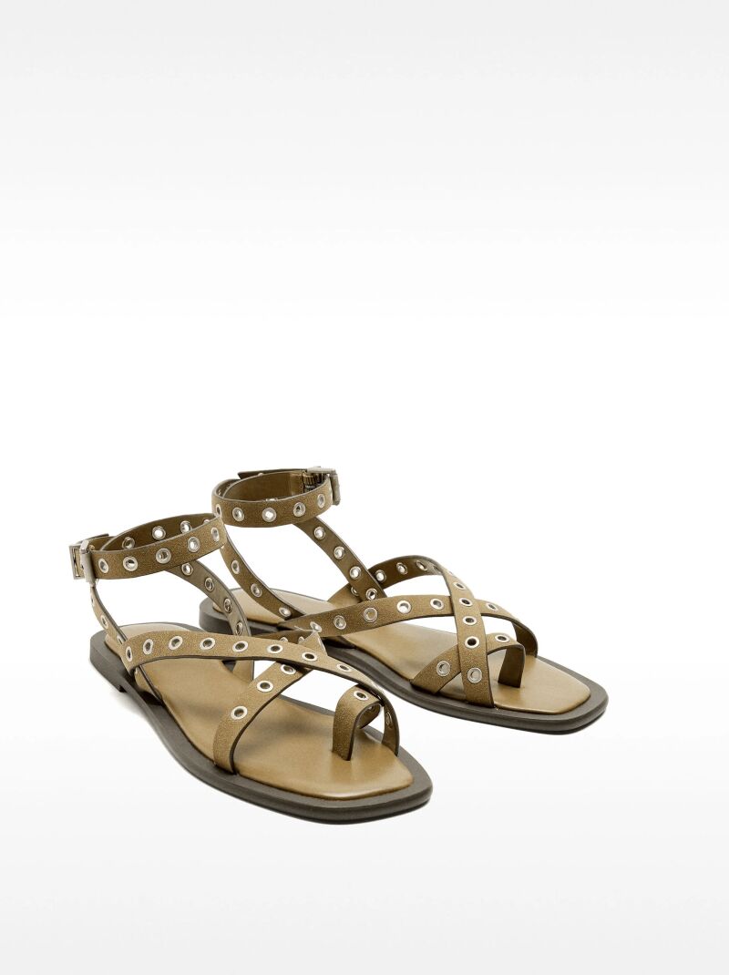 Sandalias planas con tiras y tachuelas.