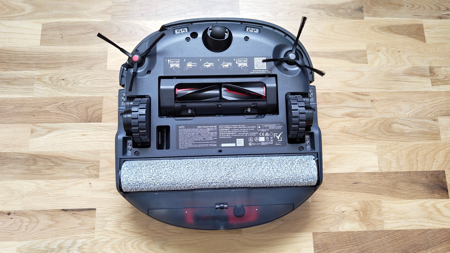 La parte inferior del Eufy Omni E25 con las tres ruedas, el cepillo "DuoSpiral", el cepillo de fregado y los dos cepillos laterales