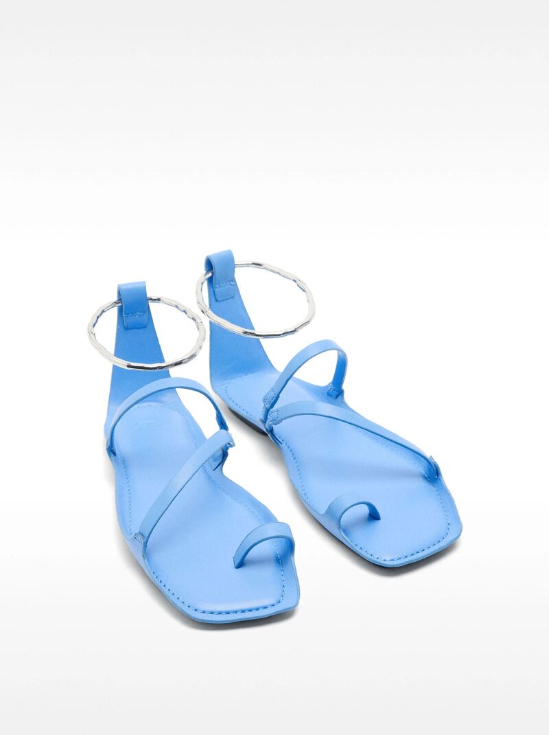 Sandalias planas de piel con anillo metálico.