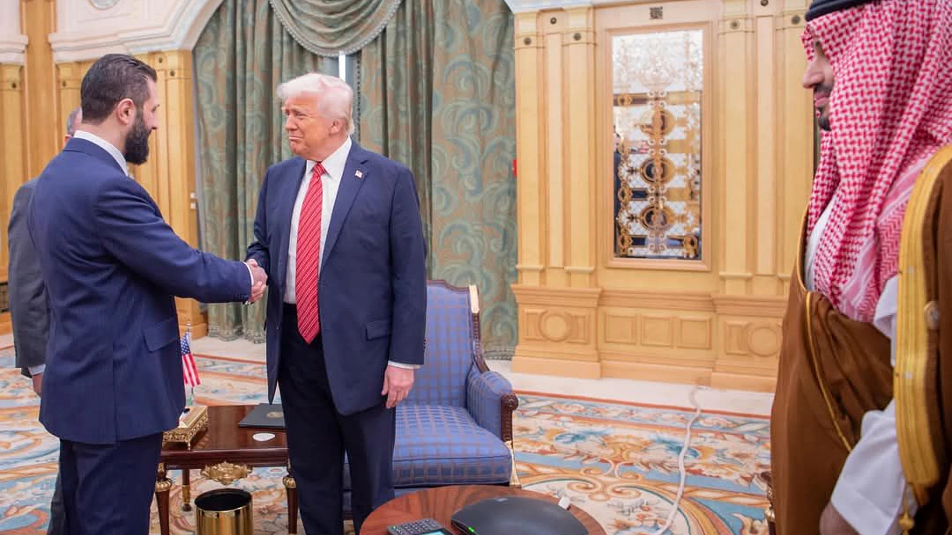 In this photo released by the Saudi Royal Palace, Syria's interim President Ahmad al-Sharaa, left, shakes hands with President Donald Trump, centre, in Riyadh, Saudi Arabia, Wednesday, May 14, 2025. At right is Saudi Crown Prince Mohammed bin Salman.(Bandar Aljaloud/Saudi Royal Palace via AP)