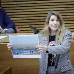 La diputada de Compromís Paula Espinosa muestra una foto de la playa de la Malvarrosa