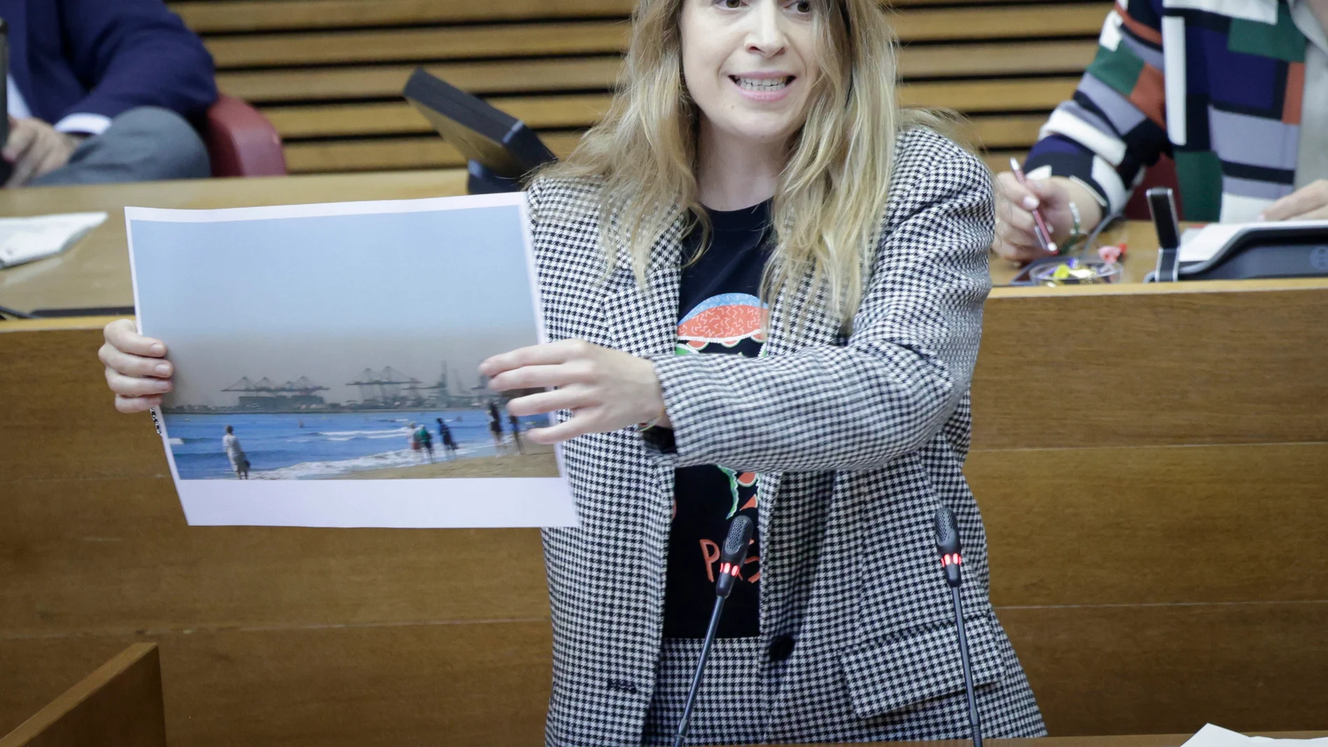 La diputada de Compromís Paula Espinosa muestra una foto de la playa de la Malvarrosa