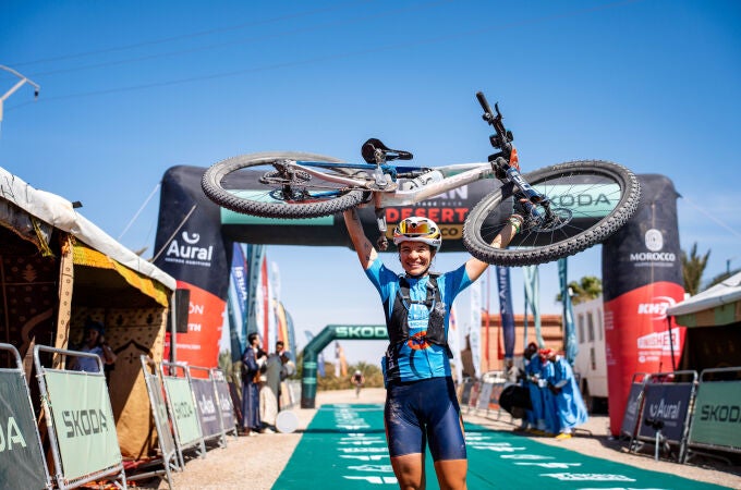 Pilar Fernández levanta su bicicleta después de ganar la Titan Desert
