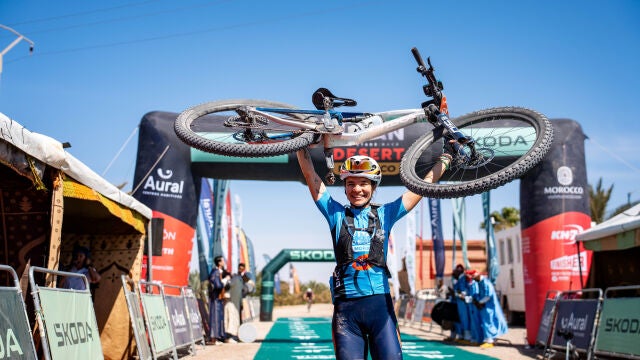 Pilar Fernández levanta su bicicleta después de ganar la Titan Desert