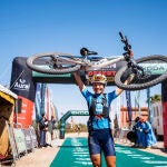 Pilar Fernández levanta su bicicleta después de ganar la Titan Desert