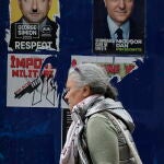 Una mujer pasa junto a carteles electorales en Bucarest