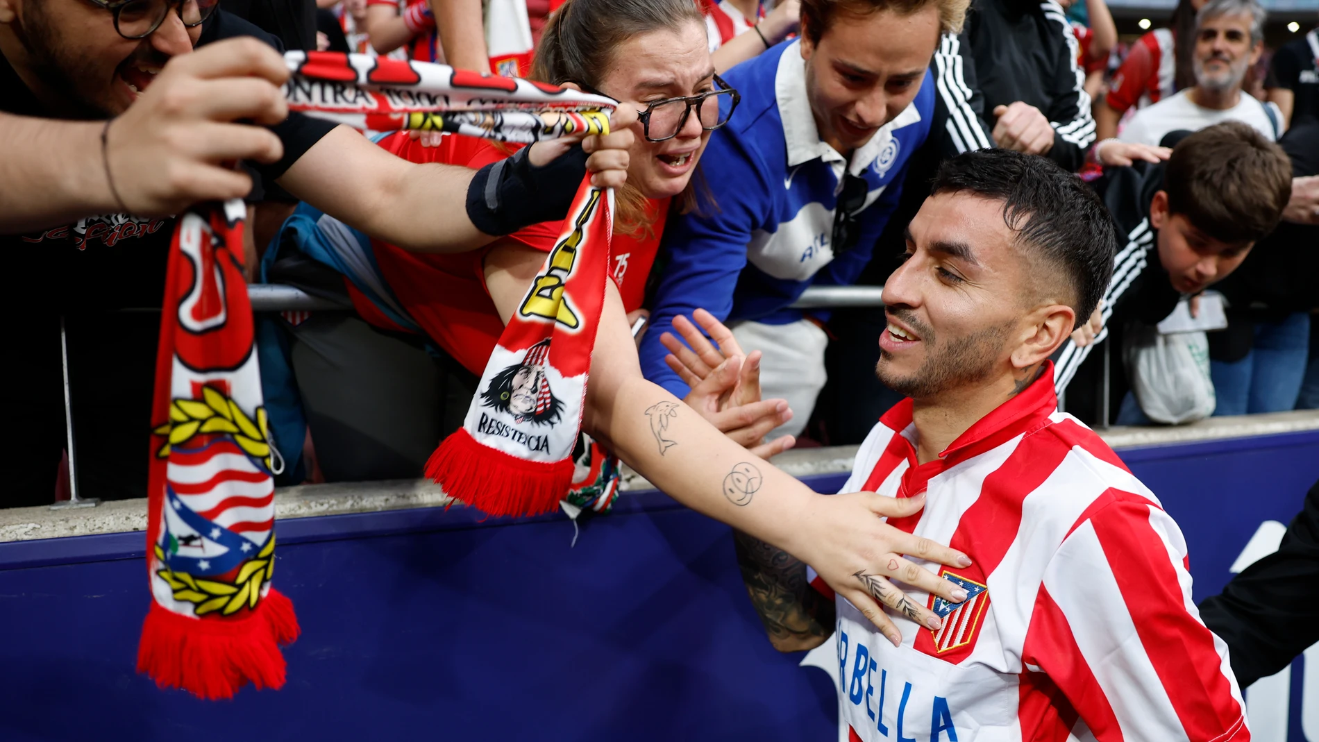 MADRID, 18/05/2025.- El delantero del Atlético de Madrid Ángel Correa (d) celebra con aficionados tras marcar el cuarto gol del partido de la jornada 37 de LaLiga contra el Betis en el Riyadh Air Metropolitano en Madrid, este domingo. EFE/ Mariscal
