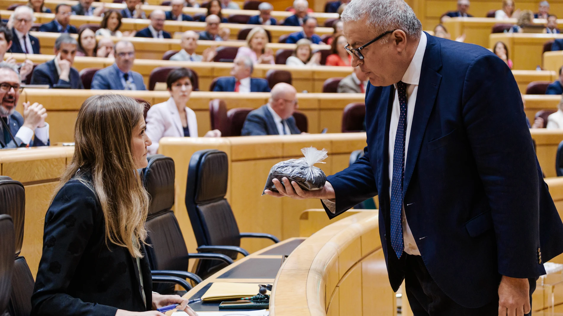 El senador del PP Francisco Bernabé entrega a la vicepresidenta tercera, Sara Aagesen, un saco lleno de estéril minero. CARLOS LUJAN | EUROPA PRESS 20/05/2025