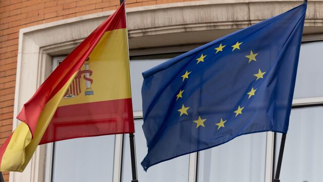 Una bandera de la Unión Europea junto a una bandera de España