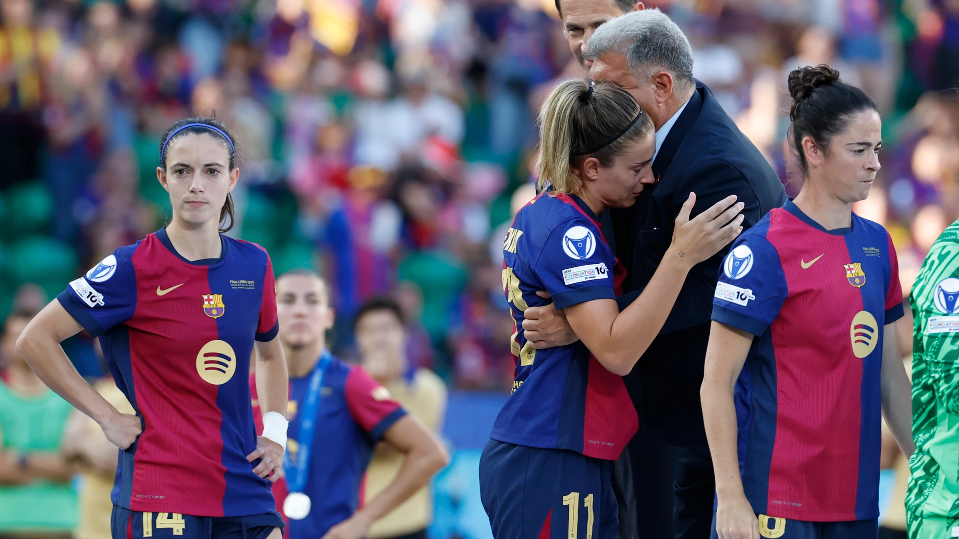 LISBOA (PORTUGAL), 24/05/2025.- La centrocampista del Barcelona Alexia Putellas (3d) se abraza con el presidente del club, Joan Laporta, tras la final de la Liga de Campeones Femenina UEFA, entre el Arsenal y el Barcelona, en el estadio José Alvalade de Lisboa (Portugal). EFE/ Toni Albir