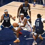Tres jugadores de los Wolves intentan frenar a Shai Gilgeous-Alexander