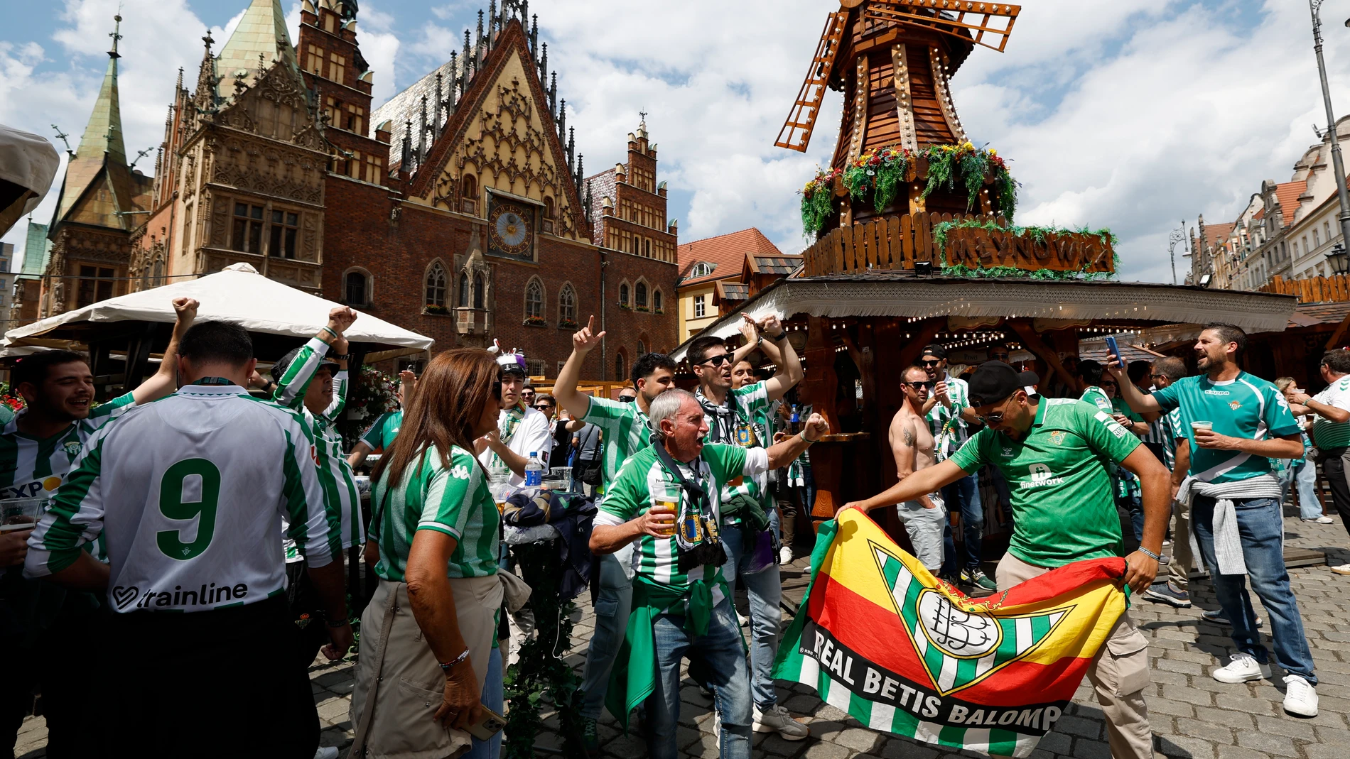 GRAFAND8728. BRESLAVIA, 27/05/2025.- Aficionados del Betis en la Plaza Solny de Breslavia (Polonia) cantan y beben un día antes de la final de la Liga Conferencia, en la que el equipo verdiblanco tiene una cita con la historia y se enfrenta ante uno de los grandes del fútbol europeo, el Chelsea inglés. EFE/Julio Muñoz