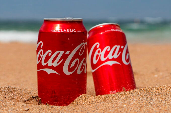 Dos latas de Coca-Cola en la playa