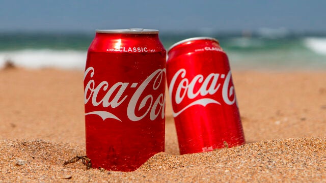 Dos latas de Coca-Cola en la playa