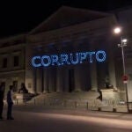 Miembros de Hazte Oír proyectan sobre la fachada del Congreso el mensaje "Sánchez corrupto".
