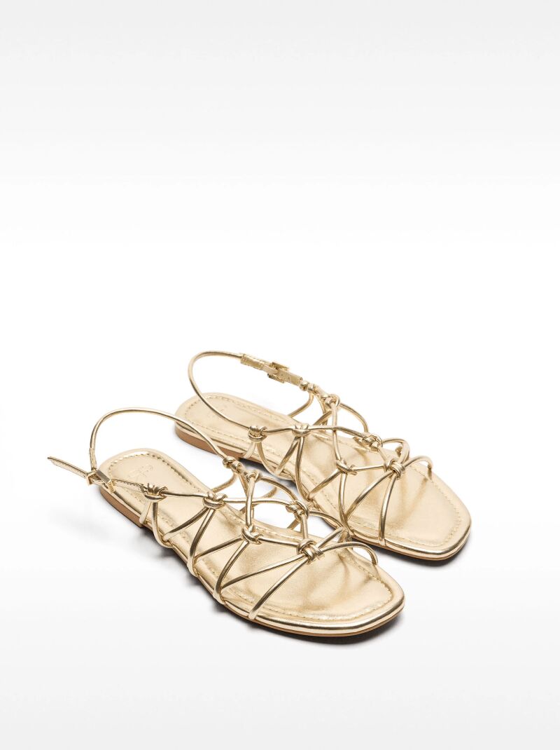 Sandalias planas con tiras cruzadas y nudos.