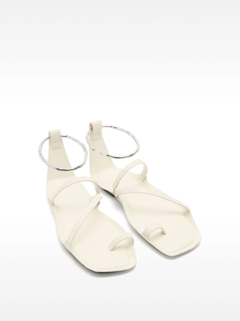 Sandalias planas de piel con anillo metálico.