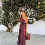 Influencer con look de invitada y sandalias planas.