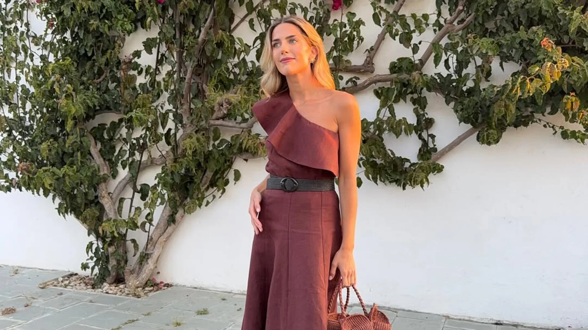 Influencer con look de invitada y sandalias planas.