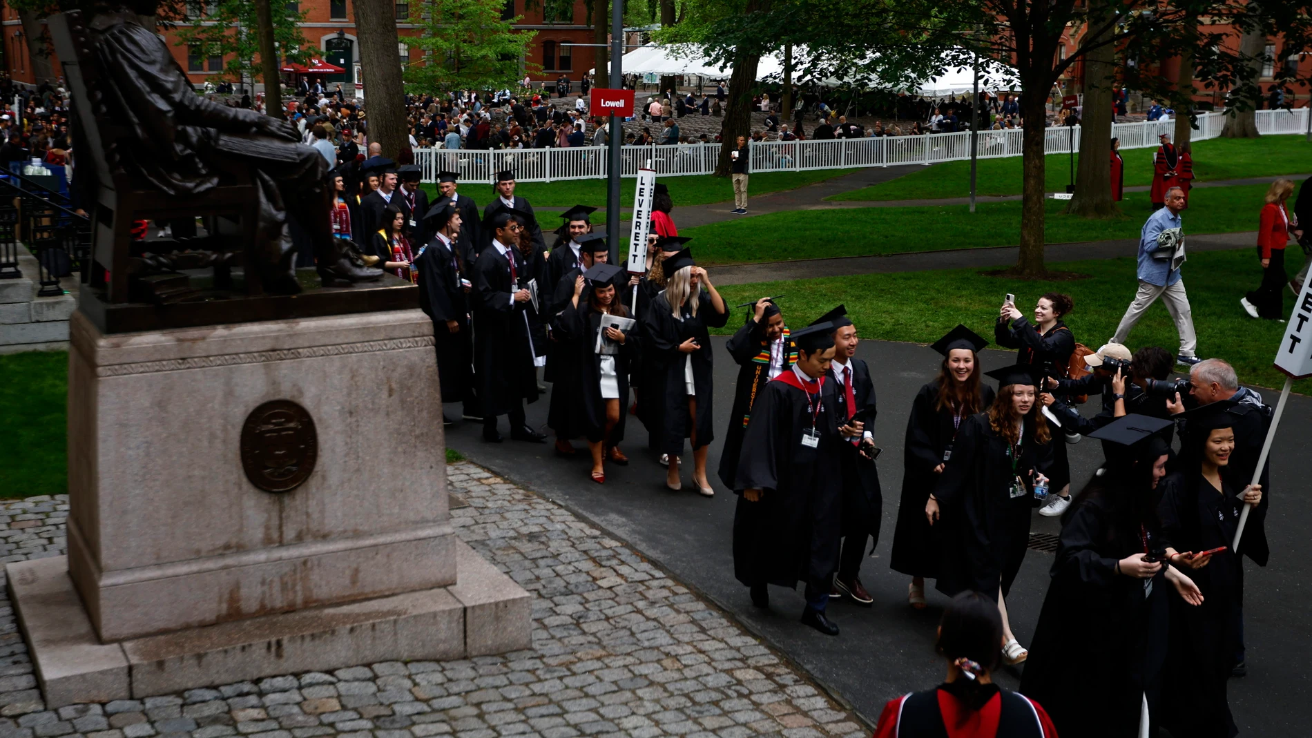CAMBRIDGE (United States), 29/05/2025.- Graduates tip their caps as they walk past the statue of John Harvard in preparation for the 374th Commencement ceremonies at Harvard University in Cambridge, Massachusetts, USA, 29 May 2025. EFE/EPA/CJ GUNTHER