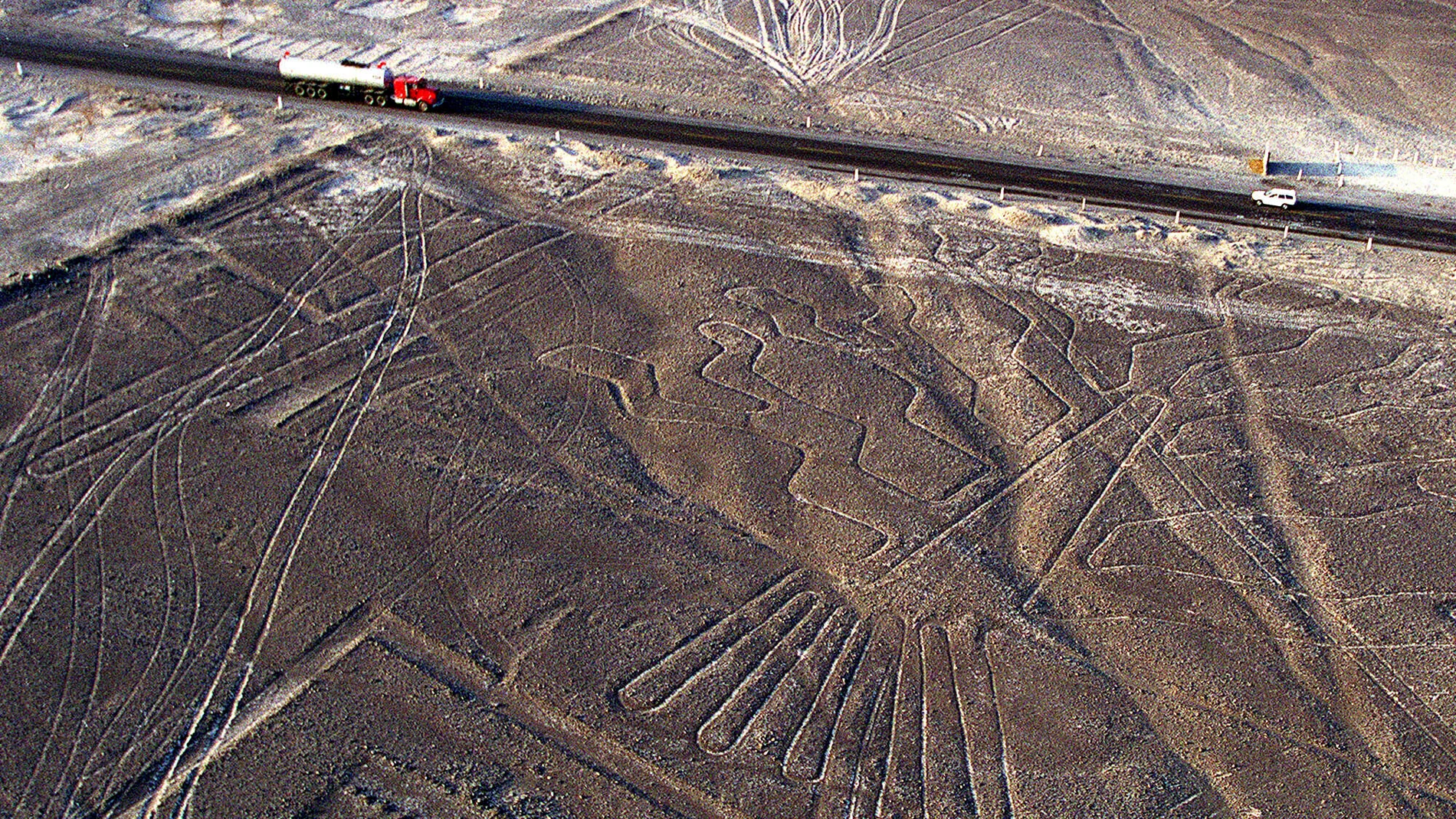FILE - The Panamerican Highway cuts through the figures and geometric shapes of the Nazca Lines near Nazca in southern Peru, June 6, 2001. (AP Photo/John Moore, File)