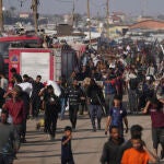 Gazatíes cargan con bolsas y cajas de ayuda humanitaria tras semanas de bloqueo