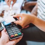 Una persona pagando con tarjeta de crédito en una cafetería