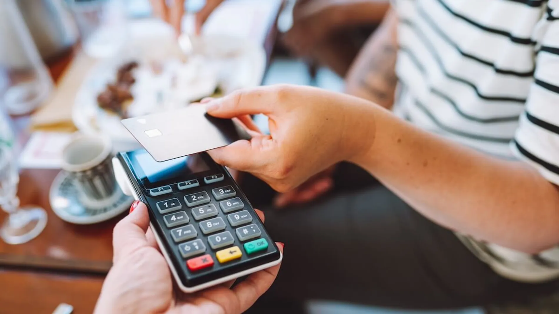 Una persona pagando con tarjeta de crédito en una cafetería