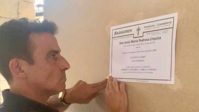 El concejal del PP, Carlos García, tapa la pintada de "Gora ETA" con la esquela de Jesús María Pedrosa, asesinado hace 25 años por ETA.