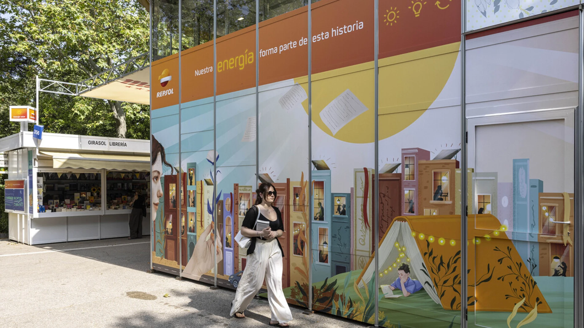 Mujer joven en la Feria Libro de Madrid 2025 sobre mural energía solar