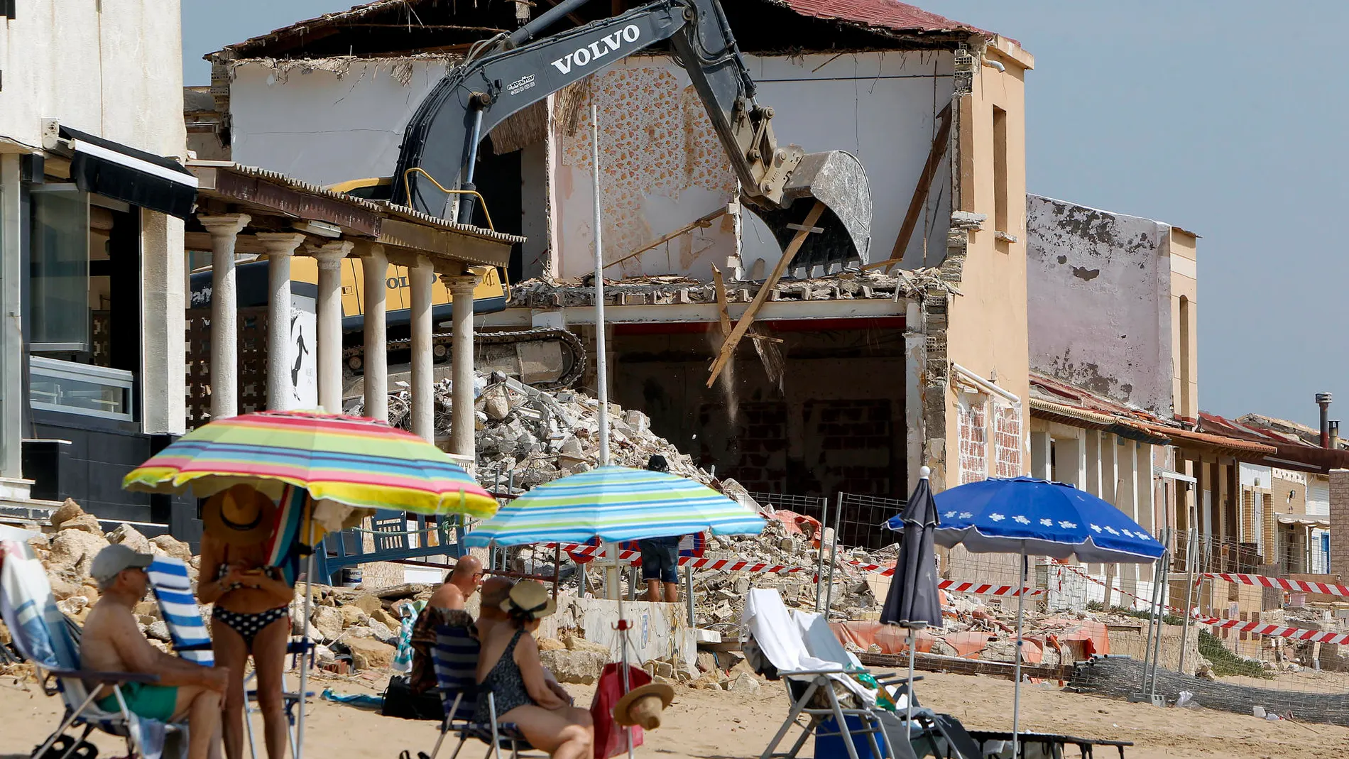 Bañistas en playa Babilonia en Guardamar del Segura, Alicante, entre cascotes
