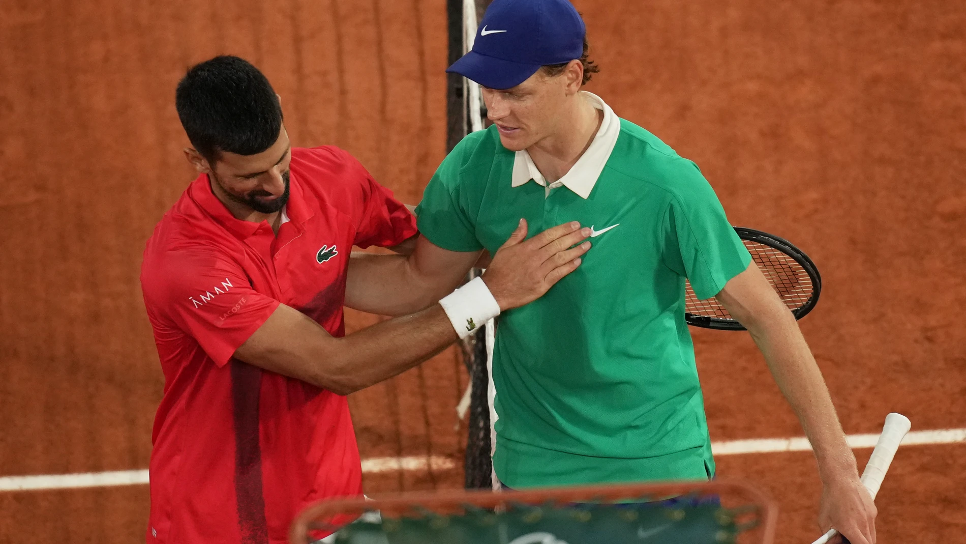 Winner Italy's Jannik Sinner, right, and Serbia's Novak Djokovic greet each other after their semifinal match of the French Tennis Open at the Roland-Garros stadium in Paris, Friday, June 6, 2025. (AP Photo/Christophe Ena)