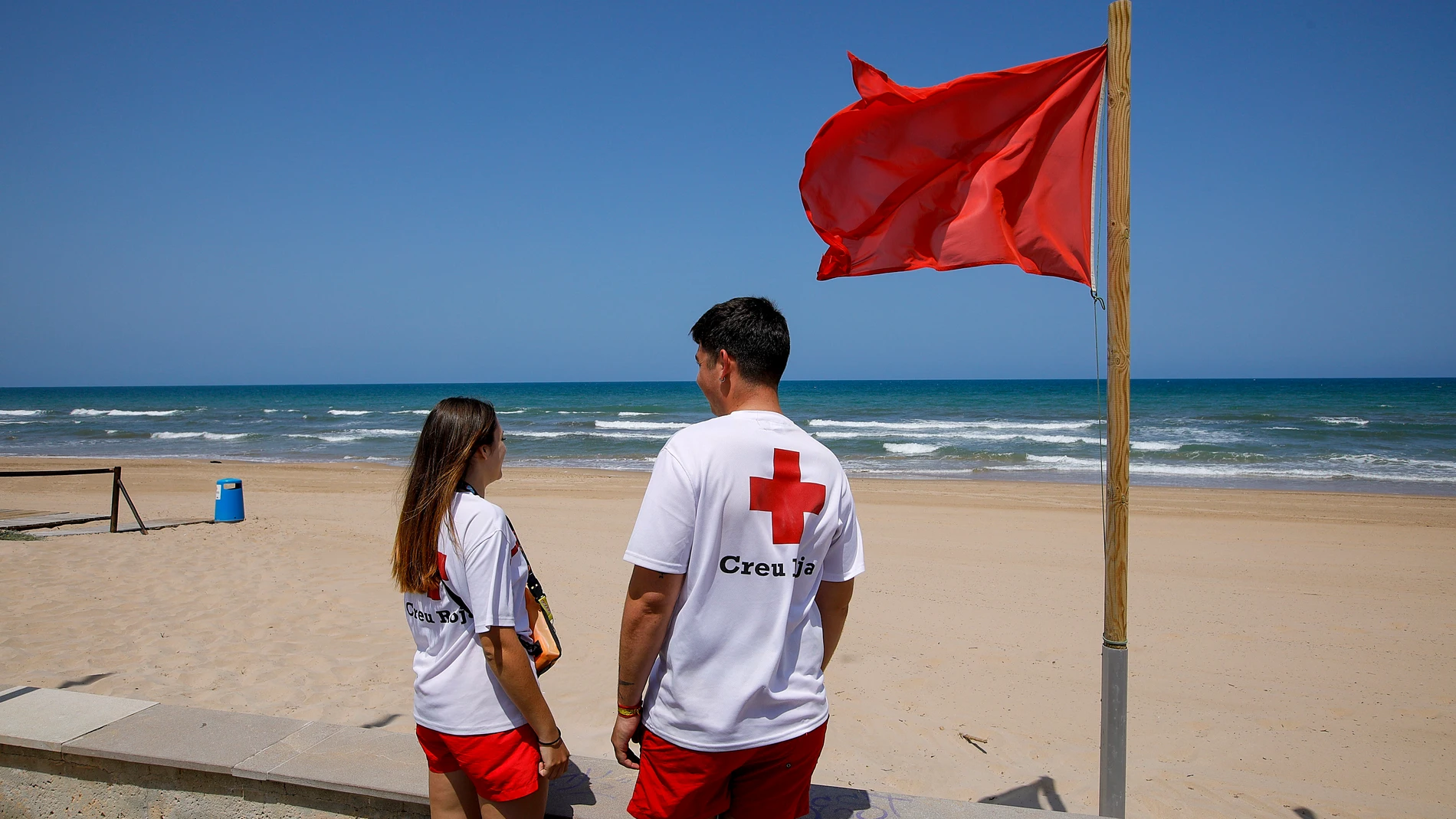 GRAFCVA8030. GUARDAMAR DE LA SAFOR (VALENCIA), 09/06/2025.- Dos socorristas aguardan en la playa de Guardamar de la Safor, una de playas del sur de la provincia de Valencia afectadas por un posible vertido marino que se han visto obligadas a cerrar al público este lunes, mientras desde la Conselleria de Medio Ambiente se han recogido muestras que ya se están analizando. EFE/Natxo Francés