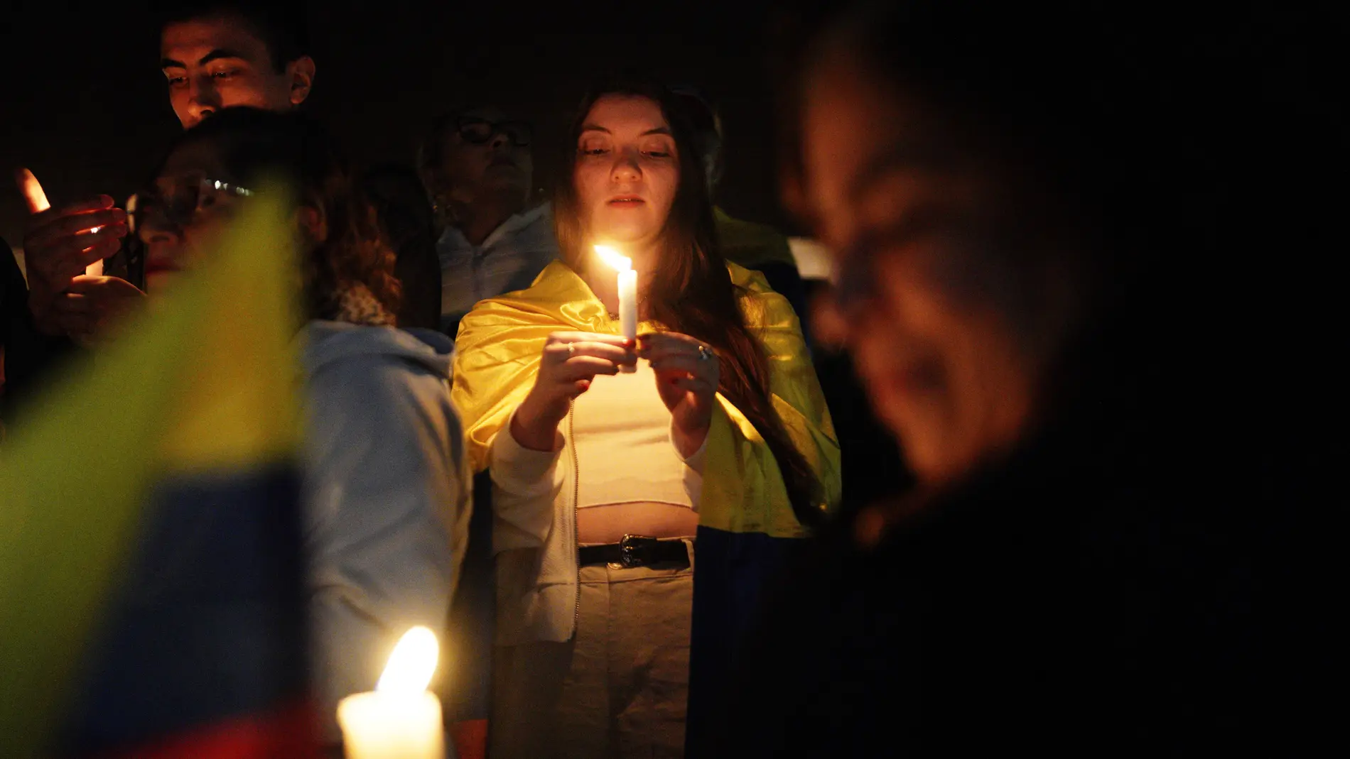People hold candles as they gather outside the clinic where Colombian Senator Miguel Uribe Turbay is being treated after he was shot at a political rally, in Bogota, Colombia, Sunday, June 8, 2025. (AP Photo/Ivan Valencia)