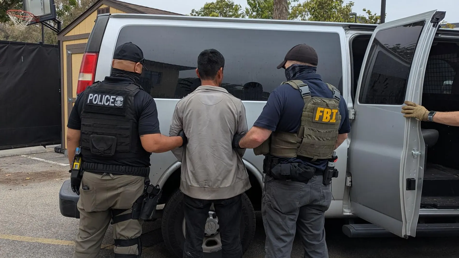 USA3150. LOS ÁNGELES (CA, EEUU), 11/06/2025.- Fotografía cedida por la Oficina Federal de Investigaciones (FBI) donde aparece uno de sus agentes acompañado por un agente del Servicio de Inmigración y Control de Aduanas (ICE) custodiando a un inmigrante a una furgoneta en el condado de Los Ángeles, California (EE.UU.). Los operativos del Servicio de Inmigración y Control de Aduanas (ICE) se han extendido a las granjas agrícolas cercanas al condado de Los Ángeles, donde ocurrieron persecuciones...
