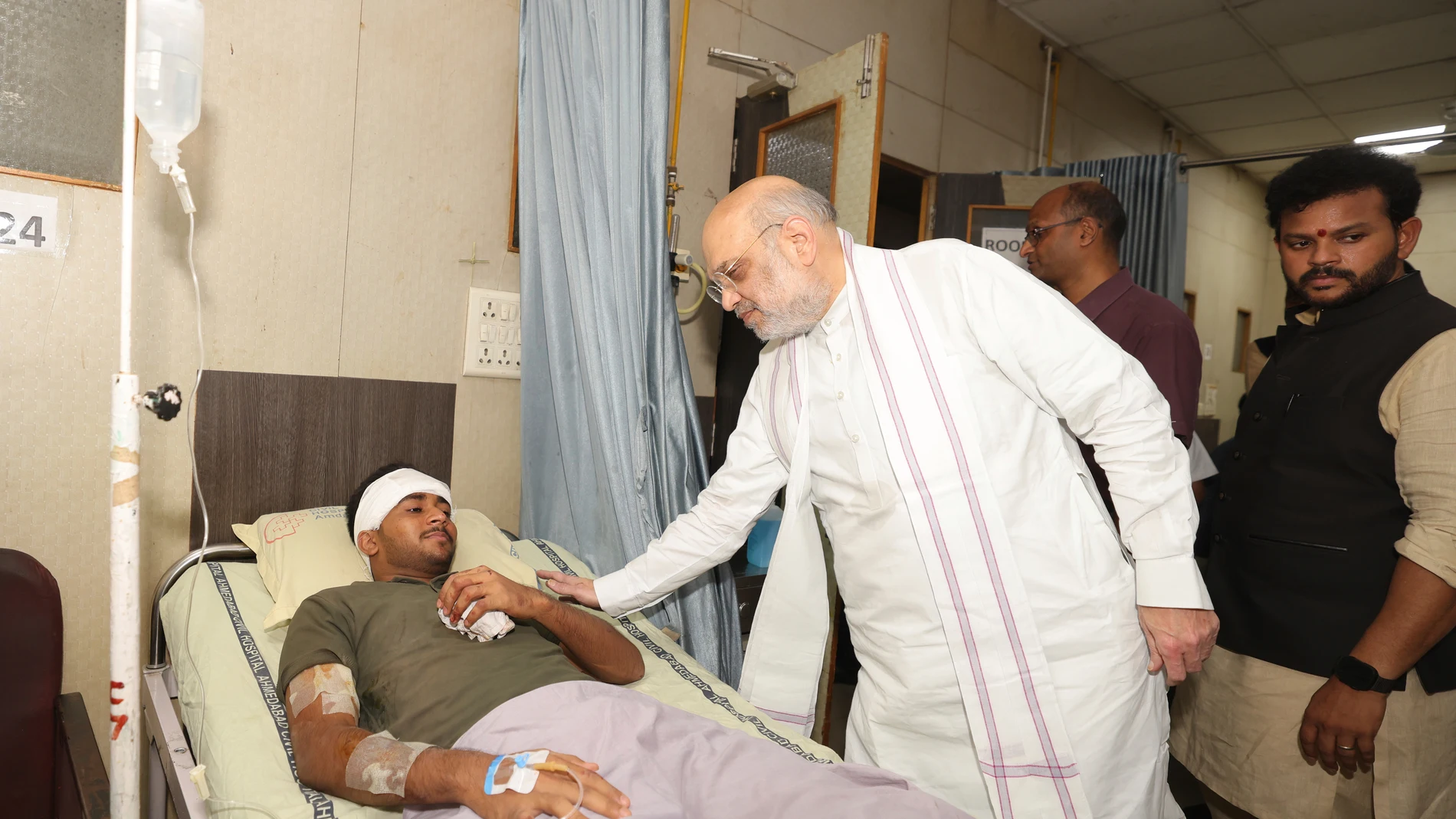 This handout photo issued by the Indian Ministry of Home Affairs shows Home Affairs Minister Amit Shah meeting British plane crash survivor Vishwash Kumar Ramesh, 40, at a hospital in Ahmedabad, after Air India confirmed Mr Ramesh was the sole survivor of the 242 people on board the London-bound Boeing 787 Dreamliner when it crashed into a medical college shortly after take-off from Ahmedabad airport. (Ministry of Home Affairs India via AP)