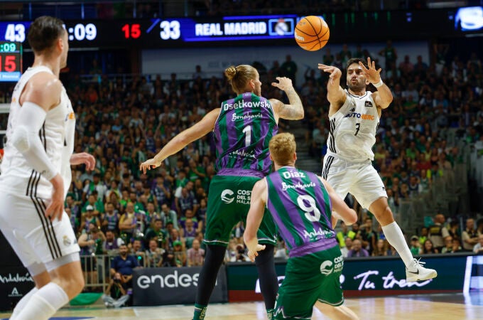 Campazzo busca a un compañero con un pase en el aire delante de Osetkowski y Díaz
