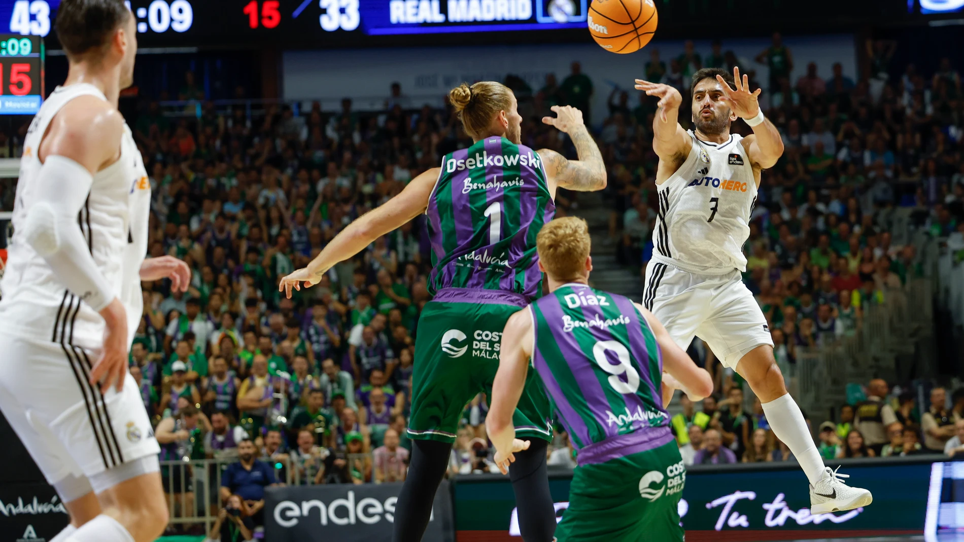 Campazzo busca a un compañero con un pase en el aire delante de Osetkowski y Díaz