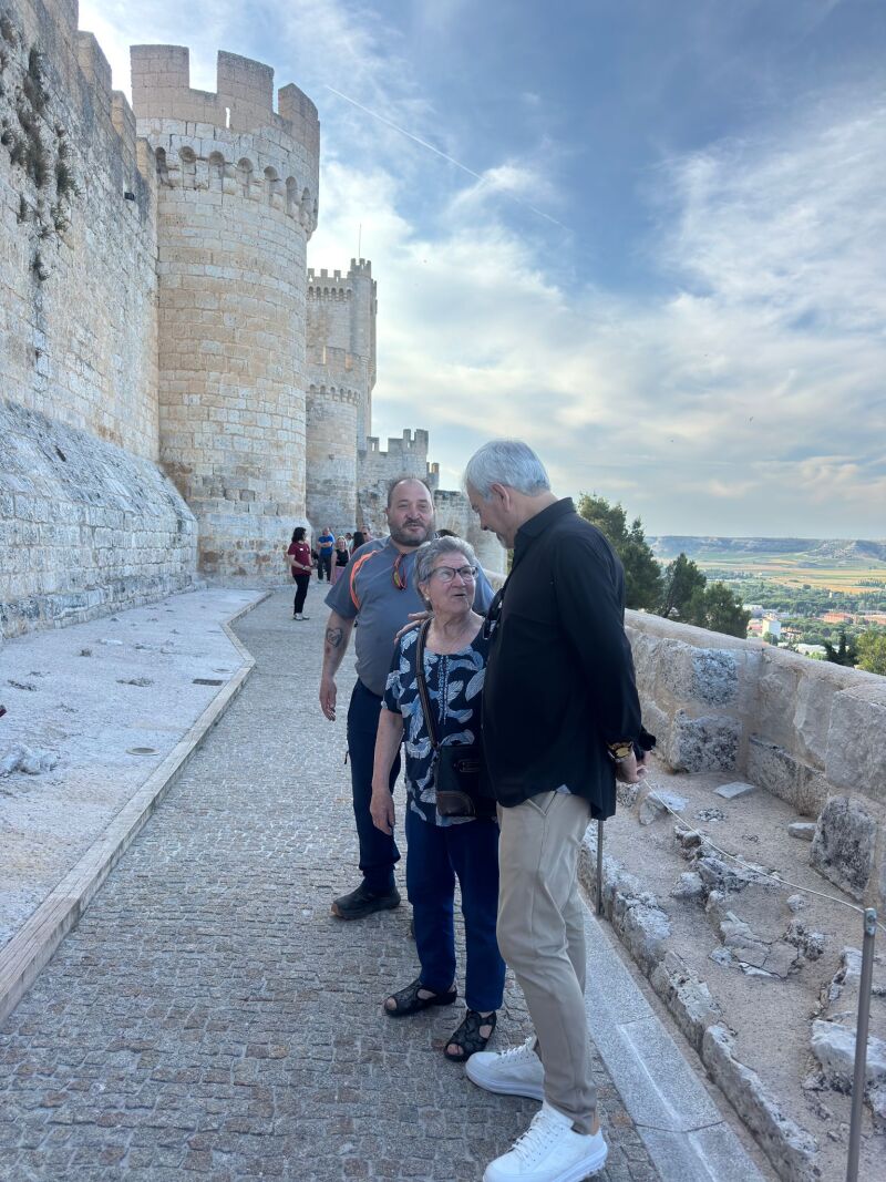 Carlos Sobera conversa con dos personas durante su visita al castillo de Peñafiel