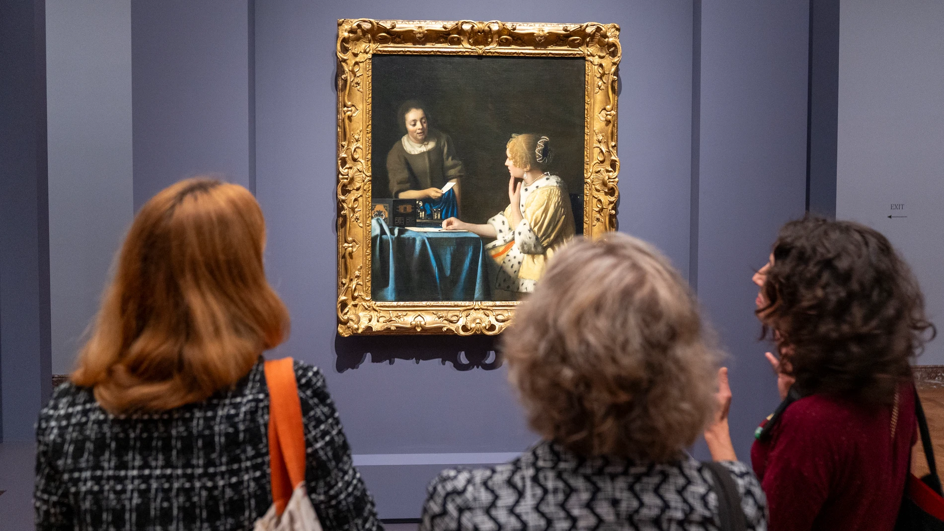AME6920. NUEVA YORK (ESTADOS UNIDOS), 18/06/2025.- Personas observan el cuadro "La amante y la criada" durante la muestra "Cartas de amor de Vermeer”, este miércoles en el museo Frick Collection en New York (EE.UU.). La presentación reúne tres cuadros del maestro holandés en los que señoras y sirvientas, retratadas en sus hogares, comparten los secretos de unas misivas aparentemente románticas. EFE/Ángel Colmenares