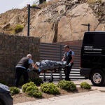 Dos operarios de la funeraria trasladan uno de los cuerpos sin vida en la urbanización Higuerón West de la localidad malagueña de Fuengirola