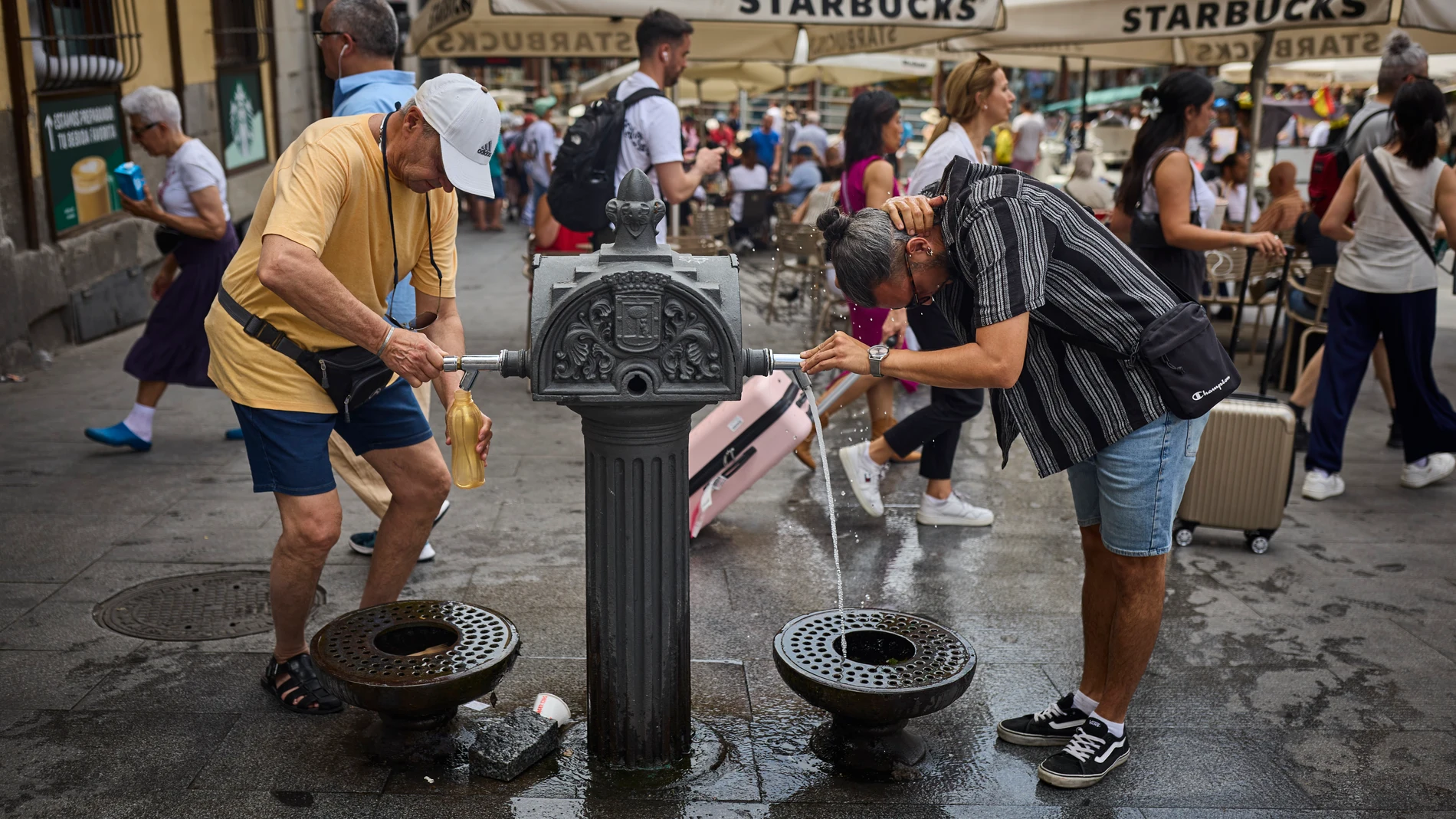 Turistas en plena ola de calor en agosto en la ciudad de Madrid intentan refrescarse en las fuentes de agua instaladas en las calles. Altas temperaturas en el centro de la ciudad. © Alberto R. Roldán / Diario La Razón. 19 06 2025