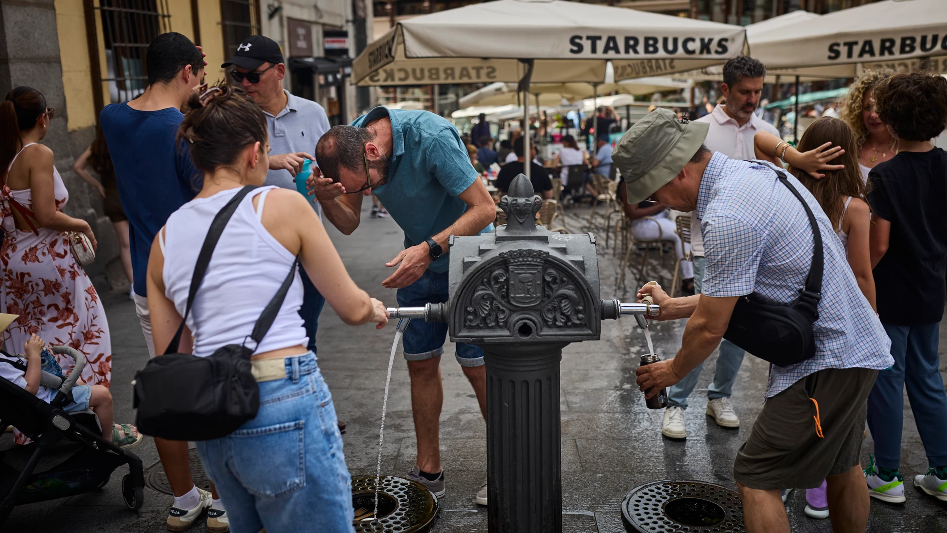 Turistas en plena ola de calor en agosto en la ciudad de Madrid intentan refrescarse en las fuentes de agua instaladas en las calles. Altas temperaturas en el centro de la ciudad. © Alberto R. Roldán / Diario La Razón. 19 06 2025
