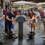 Turistas en plena ola en la ciudad de Madrid intentan refrescarse en las fuentes de agua 