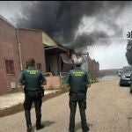 Dos guardias civiles observan el fuego en la fábrica 