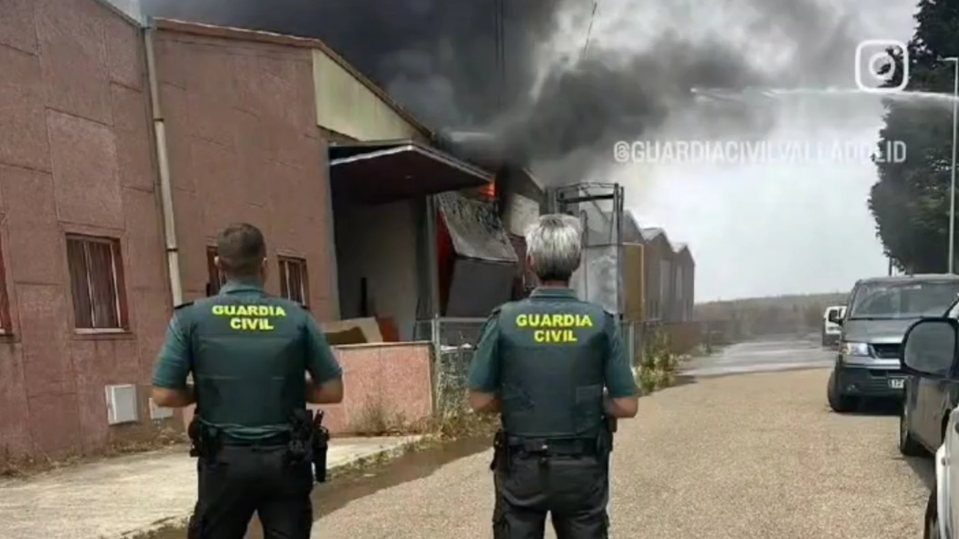 Dos guardias civiles observan el fuego en la fábrica