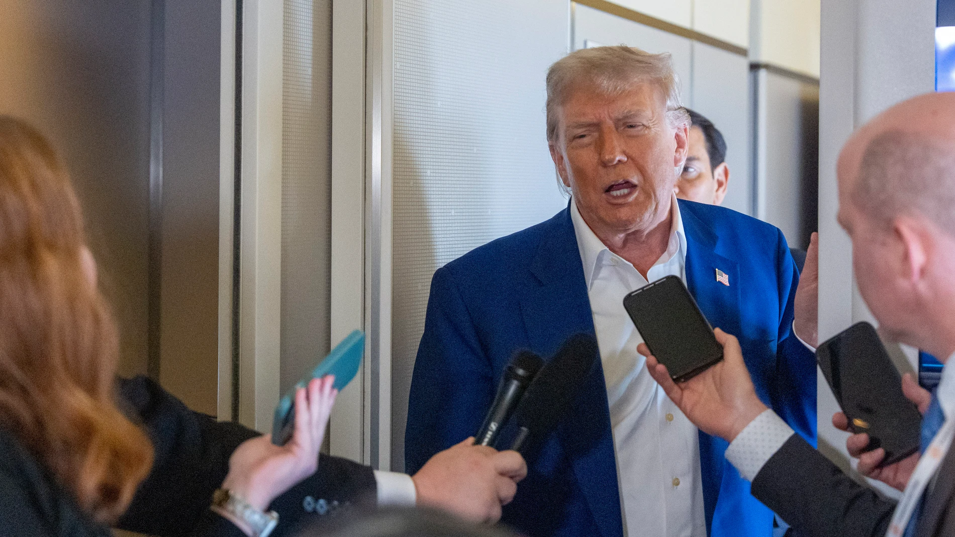 President Donald Trump speaks with reporters on Air Force One while in flight from Joint Base Andrews, Md., to Amsterdam, Netherlands, Tuesday, June 24, 2025. (AP Photo/Alex Brandon)
